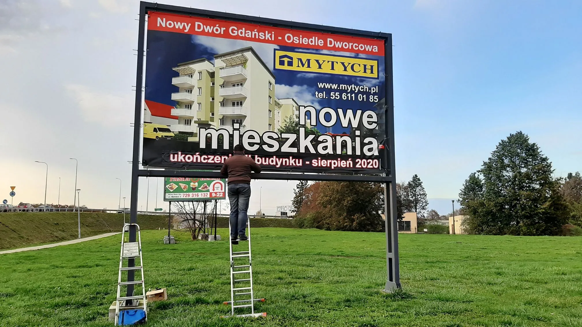 Montaż wydrukowanego banera reklamowego na billboardzie