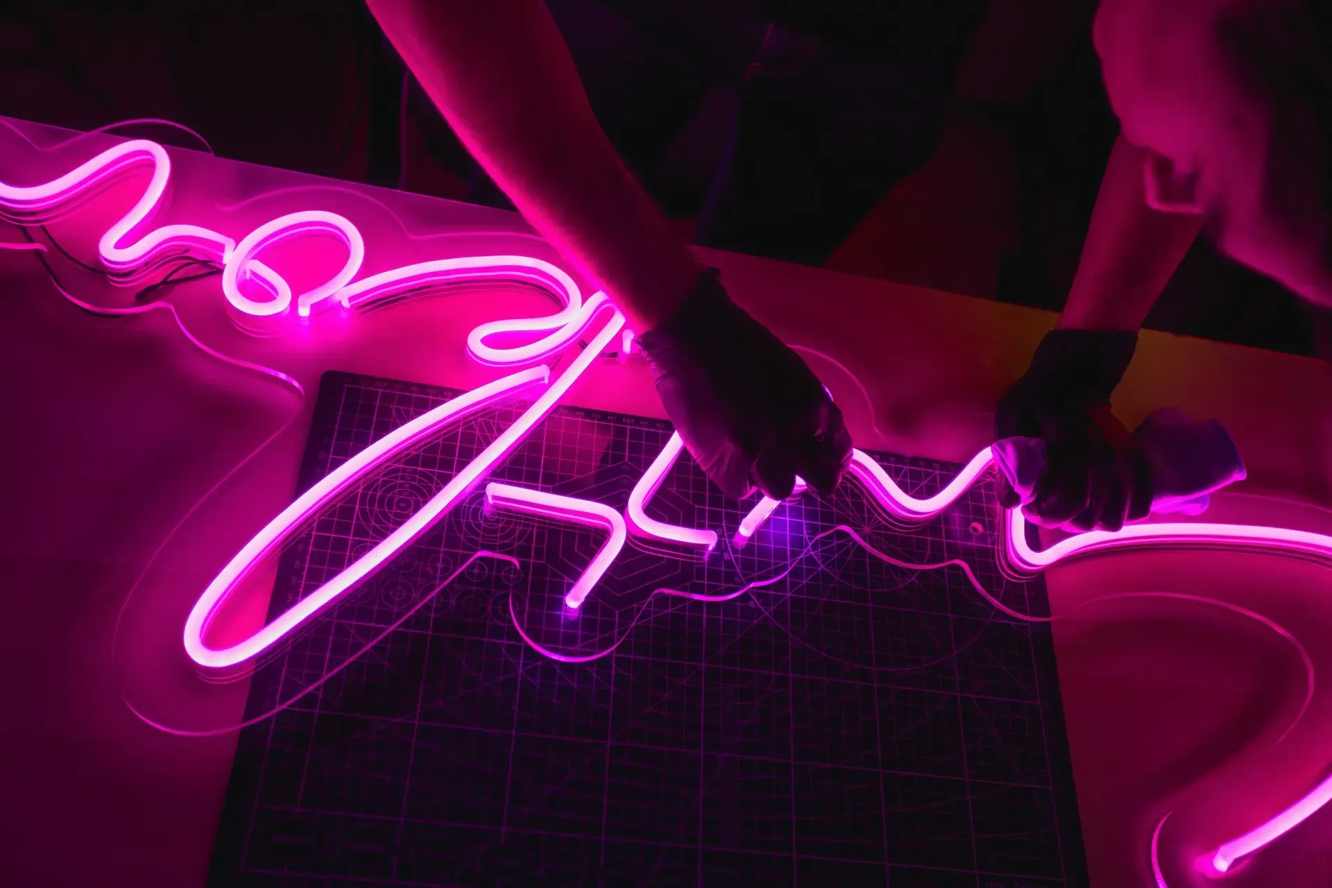 Montaż różowego neonu LED w pracowni reklamy świetlnej